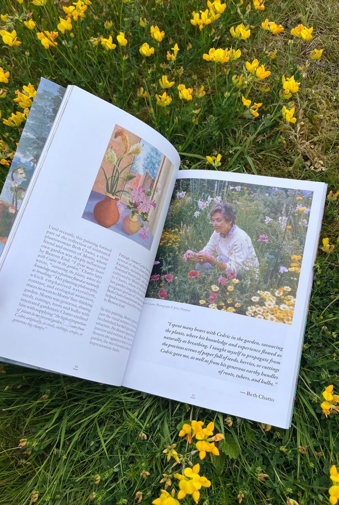 Opened book showing text, paintings and garden photography